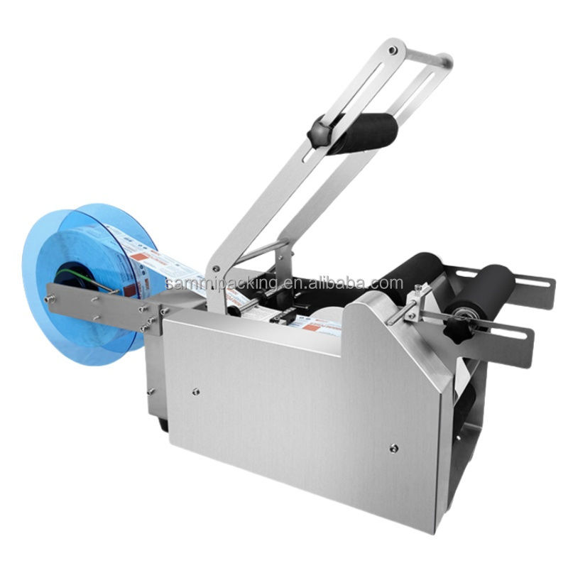 MT-50 Etichettatrice semiautomatica per etichette adesive per bottiglie e vasetti rotondi per imballaggi in metallo, carta e vetro, uso alimentare - Nuovo/Usato